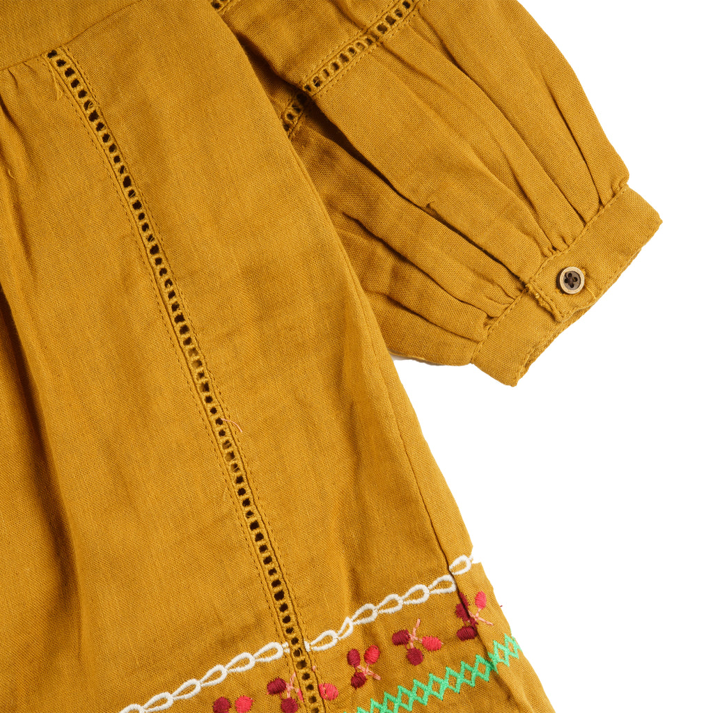 Vestido niña mostaza bambula bordado con borlas